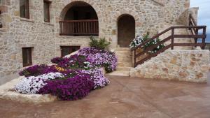 a bunch of purple and white flowers in front of a building at Simosmare Resort in Elafonisos