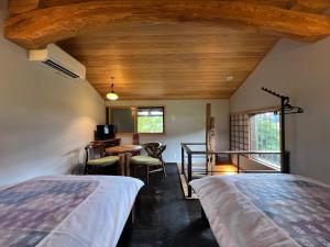 a room with a bed and a table and chairs at 板倉の宿 白栗 in Takayama