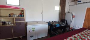 a small kitchen with a table and a refrigerator at Sapukay in Paraná