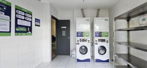 a laundry room with two washer and dryer machines at Option Full Service Residence in Rio de Janeiro