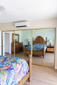 a bedroom with two beds and a mirror at Kihei Akahi A104 in Wailea +18 photos