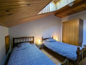 two beds in a bedroom with wooden ceilings at Gîte de charme en campagne, 5-8 pers., cheminée, nature, proche Pilat, activités à proximité - FR-1-582-269 in Saint-Romain-Lachalm