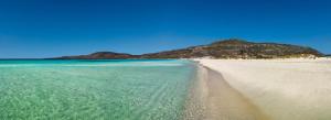 a view of a beach with an island in the background at Simosmare Resort in Elafonisos