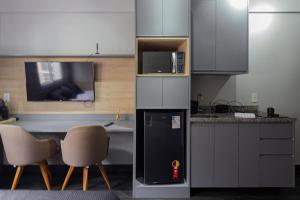 a kitchen with a refrigerator and a table and chairs at Aconchegante flat próximo a GM in São Caetano do Sul