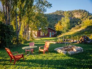 a yard with chairs and a table and a fire pit at La Maison Inukshuk, chambre no 2. in Sainte-Rose-du-Nord