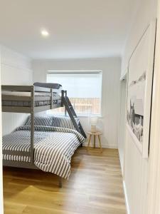 阿丁格海滩Magpie Sands - Coastal Escape & Wine Country - Beachside Getaway的一间卧室，有两张双层床和一扇窗户
