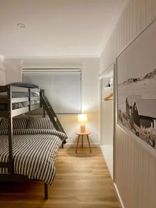 阿丁格海滩Magpie Sands - Coastal Escape & Wine Country - Beachside Getaway的客房设有一张双层床和一张带台灯的桌子。
