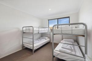 Dos literas en una habitación con ventana. en Apres 9, en Jindabyne