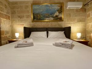a bedroom with a bed with two towels on it at L'Alba dei Sogni in Marina Serra