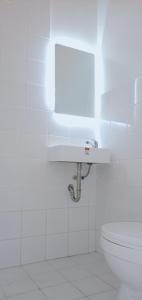 ein weißes Badezimmer mit Toilette und Waschbecken in der Unterkunft Westward Surf Zambales Beach Resort in La Paz