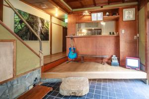 a room with a bench and a guitar in a room at Yadoya Hiraiwa private ryokan in Kyoto