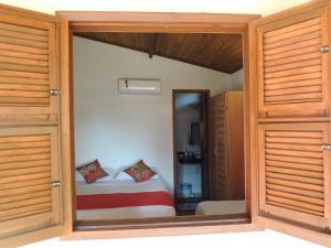 
a room with a bed and a door at Nossa Casa em Jeri in Jericoacoara
