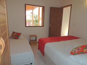 
a bedroom with two beds and two windows at Nossa Casa em Jeri in Jericoacoara
