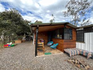 a small cabin with a couch and chairs in front of it at Cabaña Rural en Gachetá muy cerca de Bogotá - Santa Jacoba in Gachetá