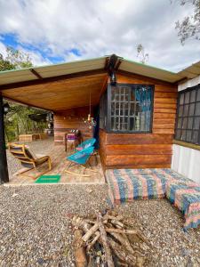 a wooden cabin with a couch and chairs on a patio at Cabaña Rural en Gachetá muy cerca de Bogotá - Santa Jacoba in Gachetá +18 photos
