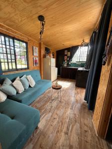 a living room with a blue couch and a table at Cabaña Rural en Gachetá muy cerca de Bogotá - Santa Jacoba in Gachetá