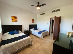 a bedroom with two beds and a ceiling fan at Mayan Playa Departamento Uxmal in Acapulco +13 photos