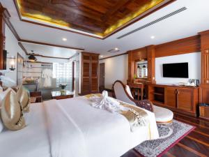 una camera da letto con un letto bianco e una TV a schermo piatto di The Night Hotel a Siem Reap