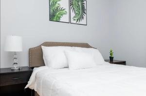 a bedroom with a bed with white sheets and a lamp at Spacious Family Retreat - Churchill Downs & Downtown in Louisville