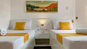 two beds sitting next to each other in a room at Bohol Emerelle's Tourist Inn in Dauis