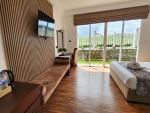 a hotel room with a bed and a large window at Cottage Mountain Misty-Nuwaraeliya in Nuwara Eliya