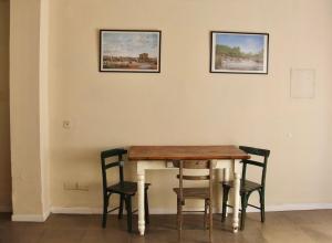 a dining room table with chairs and two pictures on the wall at La Elegida in San Antonio de Areco