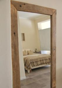 a mirror in a bedroom with a bed at La Elegida in San Antonio de Areco