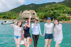 un grupo de mujeres de pie en un barco en el agua en Sunrise Catamaran Yacht Tour, en Nha Trang