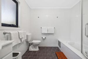 Un baño blanco con inodoro y bañera. en Albina, en Thredbo 20 fotos más