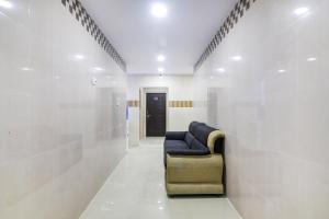 a waiting room with a blue couch in a white wall at Hotel O Aroma Classic Near Nampally Railway station in Hyderabad