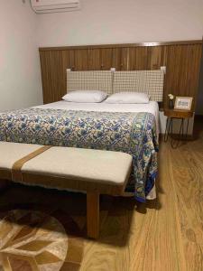 a bedroom with a large bed with a wooden headboard at Casa de Campo Completa Cabanas Monte Sierra in Urupema