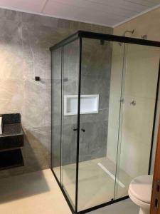 a glass shower in a bathroom with a toilet at Casa de Campo Completa Cabanas Monte Sierra in Urupema +41 photos