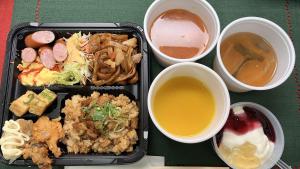 广岛Toyoko Inn Hiroshima-eki Minami-guchi Migi的黑色食物托盘,包括不同的食物和饮料