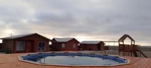 a house with a swimming pool and a playground at Cabañas Tres Islas in Punta de Choros