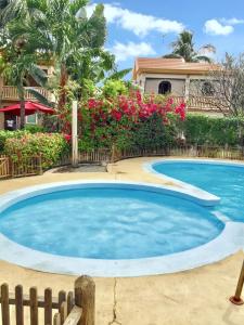 una gran piscina azul frente a una casa en Spacious House in Flic en Flac with Shared Pool, en Flic en Flac