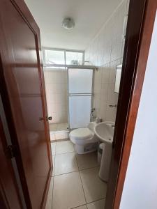 a bathroom with a toilet and a sink at Departamento Punta Centinela frente al mar in Santa Elena