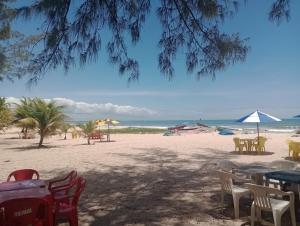 a beach with tables and chairs and the ocean at Casa do Guaibim in Valença