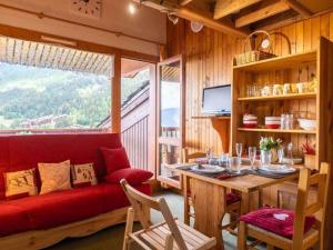 ein Wohnzimmer mit einem roten Sofa und einem Tisch in der Unterkunft Studio alpin mezzanine, 4 pers, animaux acceptés, parking en option - FR-1-291-1022 in Valmorel
