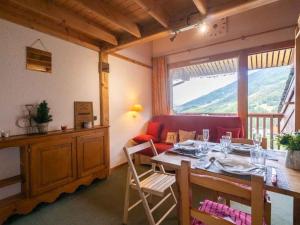 ein Esszimmer mit einem Tisch und einem roten Sofa in der Unterkunft Studio alpin mezzanine, 4 pers, animaux acceptés, parking en option - FR-1-291-1022 in Valmorel + 2 Fotos