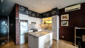 a kitchen with a refrigerator and a stove at Spacious and Restful 2BR at Sumatra36 Apartment By Travelio in Surabaya