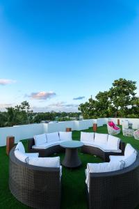 a group of wicker chairs and a table on a lawn at Island Vista Thoddoo in Thoddoo +15 photos