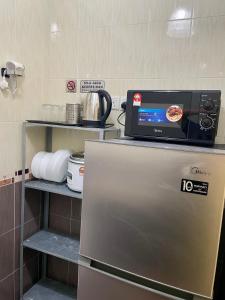 - une cuisine avec une pizza au-dessus d'un réfrigérateur dans l'établissement 2 Bedroom Port Dickson Seaview, à Port Dickson