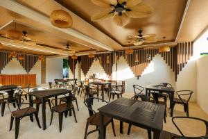 a restaurant with tables and chairs and ceiling fans at Island Vista Thoddoo in Thoddoo
