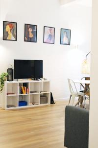 a living room with a tv on a white cabinet at Cozy Stay in City Center in Livorno