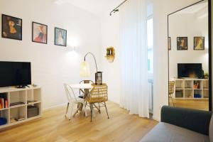a white living room with a table and chairs at Cozy Stay in City Center in Livorno