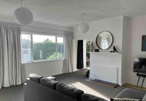 a living room with a couch and a large window at 10 Nikau Place in Christchurch +1 photo
