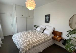 a bedroom with a bed and a chandelier at 10 Nikau Place in Christchurch