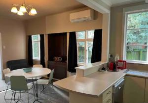 a kitchen with a table and a table and chairs at 10 Nikau Place in Christchurch