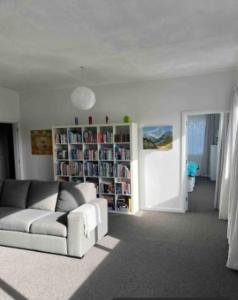 a living room with a couch and a book shelf at 10 Nikau Place in Christchurch