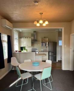 a dining room and kitchen with a table and chairs at 10 Nikau Place in Christchurch